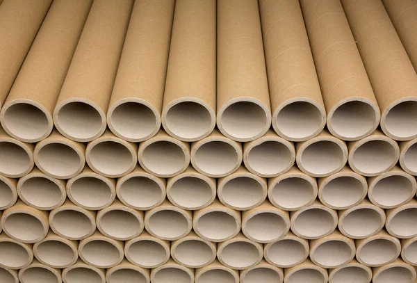 A bunch of brown industrial paper core. A lot of paper cores or paper tubes. Brown paper rolls.