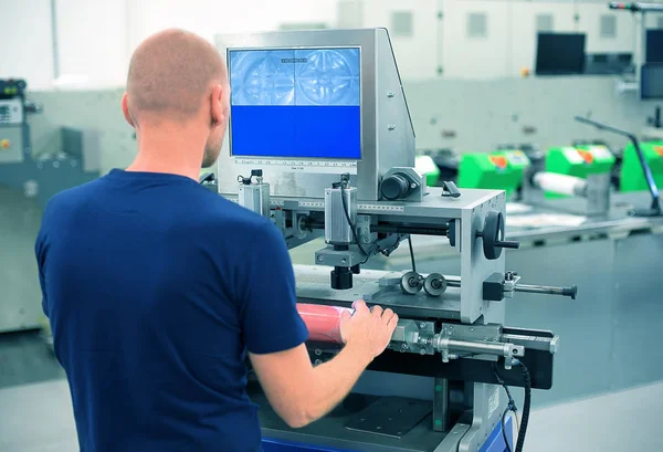 Bir baskı ve basın merkezinde çalışan makine montaj plakası polimer kabartma plaka üzerinde bir baskı silindir eklemek için kullanır. Montaj fleksografik baskı makinesi için baskı kalıbının gösterilen sahne.