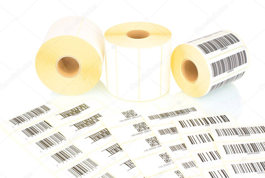 White label rolls and printed barcodes isolated on white background with shadow reflection. White reels of labels for printers. Labels for direct thermal or thermal transfer printing. Barcode samples.