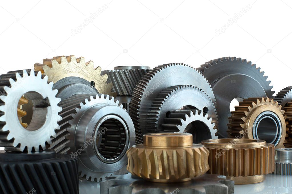Sets of gears, cogwheels made of steel and brass isolated on white background with shadow reflection. Helical and spur gears,some with bearing isolated on white background with shadow reflection.