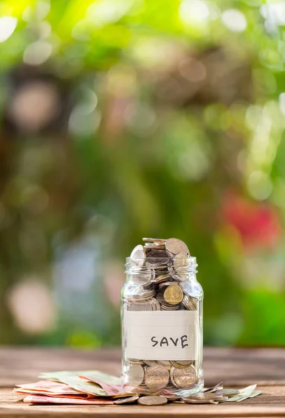 Savings Deposit Coins Clear Glass Bottle Wooden Floor Bokeh Background — Stock Photo, Image