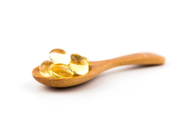 Beyaz arka plan ile bir tahta kaşık sağlıklı vitamin.