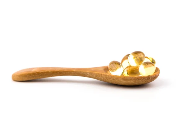 Beyaz arka plan ile bir tahta kaşık sağlıklı vitamin.