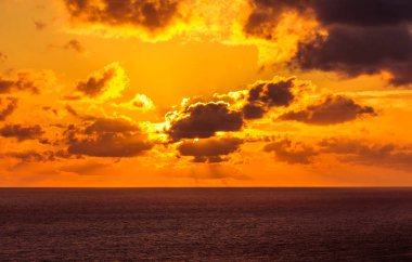 Bulutlar tarafından gizli güneşin denize iner