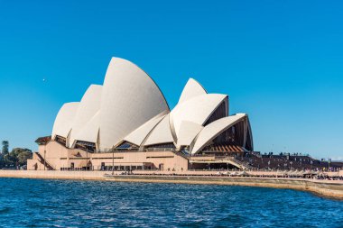 Sydney, Avustralya - 23 Temmuz 2016: Sydney Opera binası zemin üzerine mavi gökyüzü ile güneşli Bennelong noktasında