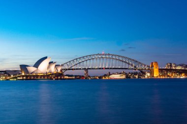 Sydney, Avustralya - 07 Kasım 2014: Sydney Opera Binası ve Sydney Harbour Bridge geceleri. Avustralya Simgesel yapılar