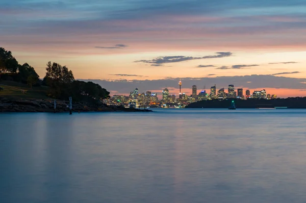 夕暮れ時、夕日のシドニー都市景観の遠くのシルエット — ストック写真