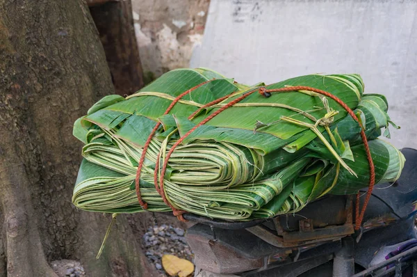 ஸ்கூட்டரில் பிணைக்கப்பட்ட மடிந்த பனை இலைகள், கயிறு கொண்ட சைக்கிள் — ஸ்டாக் புகைப்படம்