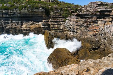 Dağ uçurum ve güçlü okyanus dalgalarının güneşli. Doğa güç deniz manzarası. Deniz kızları giriş, Avustralya
