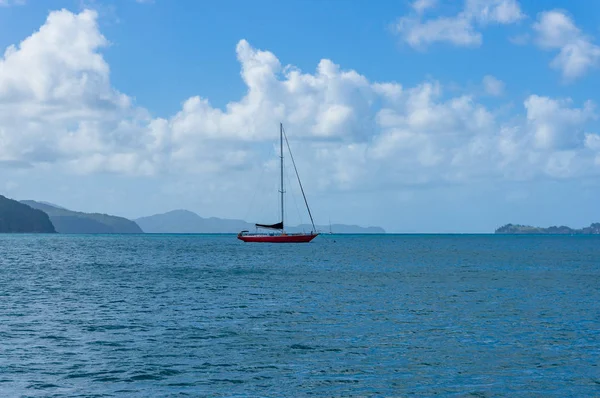 赤い帆船 遠くにサンゴ礁の島々と穏やかな海のヨット ウィットサンデー オーストラリア — ストック写真