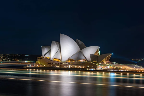 Sydney Opera House por la noche con senderos de luz sobre el agua — Foto de Stock