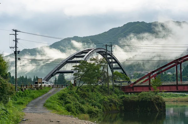 Пейзаж моста с горами и низкими облаками на backgrou — стоковое фото