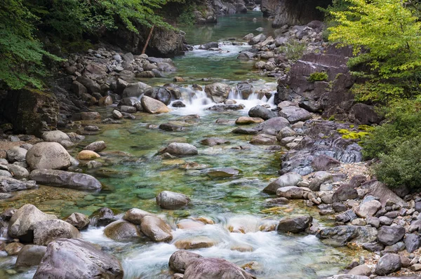 Wasser strömt über Steine. Gebirgsfluss aus nächster Nähe — Stockfoto