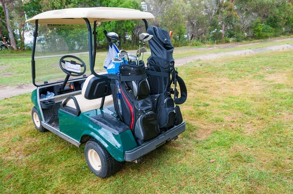 Carro de golfe no gramado verde do campo de golfe — Fotografia de Stock