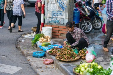 Vietnamlı kadın sokak m kaldırımda tropikal meyve satan