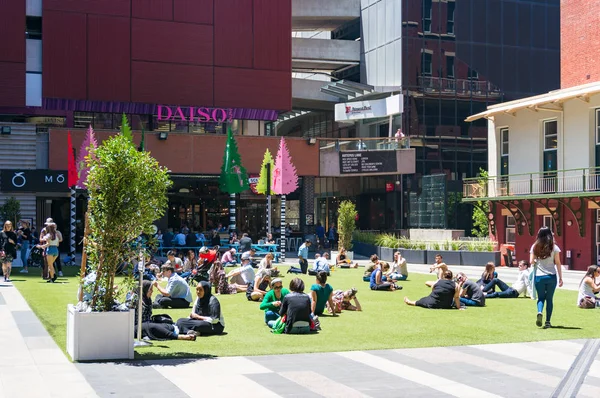 Personnes multinationales se relaxant sur la pelouse verte à Melbourne CBD — Photo