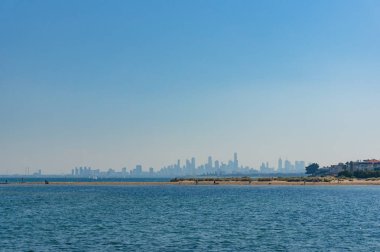 Arka planda gökdelenler ile şehir manzarası ile Mavi okyanus