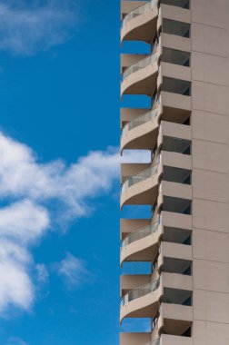 T mavi gökyüzüne karşı kıvrımlı balkon mimarisi arka plan