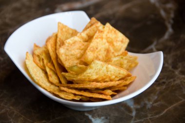 Cips, masada beyaz tabakta baharat ile cips