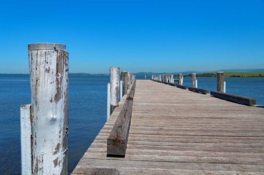 Uzun ahşap iskele, mavi okyanus ve berrak gökyüzü ile iskele