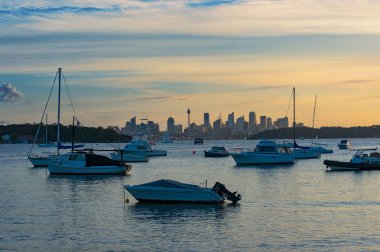 Gün batımında arka planda Sydney Cbd ile yatlar ve tekneler