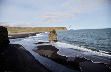 Siyah kumlu plajı ile mavi deniz doğal görünümü