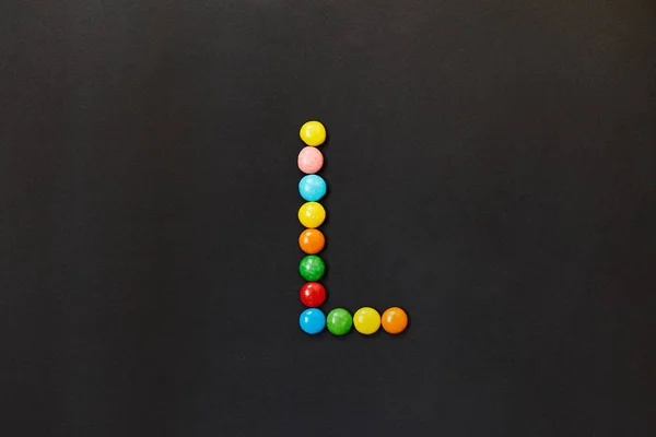 English Alphabet made of colored candies. The letter L.