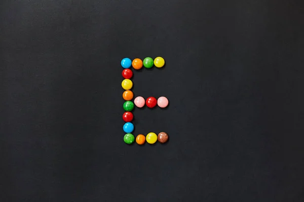 English Alphabet made of colored candies. The letter E.