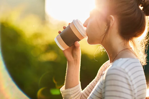 夕暮れ時 紙コップからコーヒーを飲む若い女性 — ストック写真