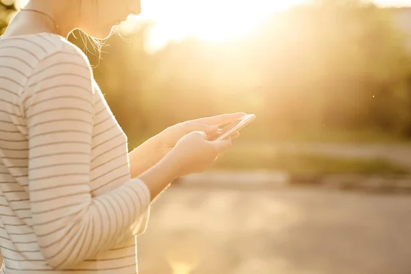 La fille regarde à travers les réseaux sociaux sur votre téléphone — Photo