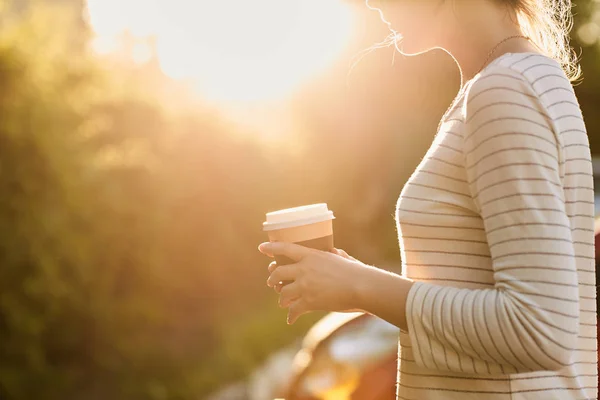 紙公園でカップからコーヒーを飲む若い女の子。ホット コーヒー。熱いお茶 — ストック写真