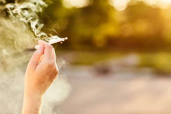 Girl holding a Smoking cigarette at sunset. — Stock Photo, Image