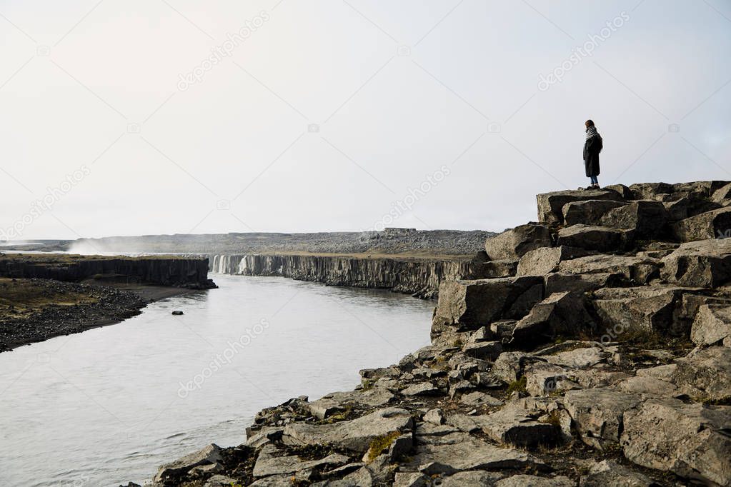 Young girl looking at the landscape. She admires the nature of Iceland.