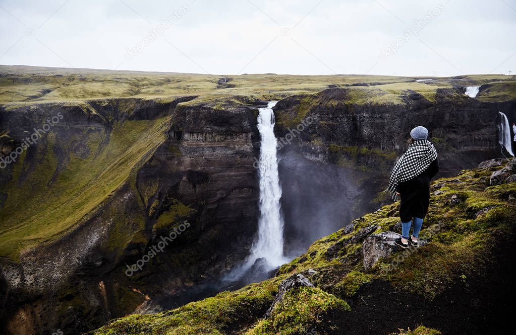 Young girl looking at the landscape. She admires the nature of Iceland. 