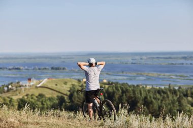 Bisikletçi. Genç bir adam bir bisiklet üzerinde. Dinlenme ve sahne hayran