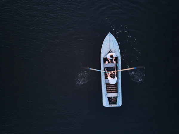 Two guys rolling around on a boat on the river. The view from the top.