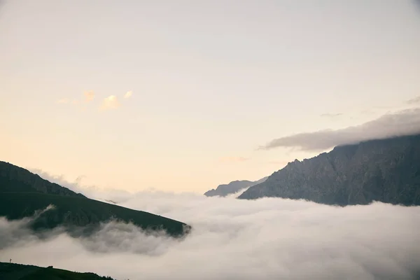 Montañas en las nubes al atardecer. Montañas caucásicas de Georgia . —  Fotos de Stock