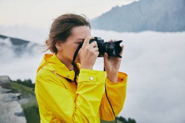 Genç bir kız sarı yağmurluk içinde dağlar fotoğraflar. Gürcistan. Yaz. Ağustos. Kız bir fotoğraf çekimi Dağı'nın yapım. 