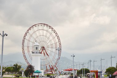 Kırmızı bir dönme dolap ve bir erkek ve bir kadın heykeli.