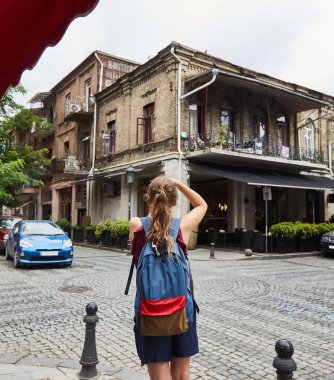 Genç bir kız eski binalar fotoğraflar. Turist kız eski şehir fotoğraflarını çeker.