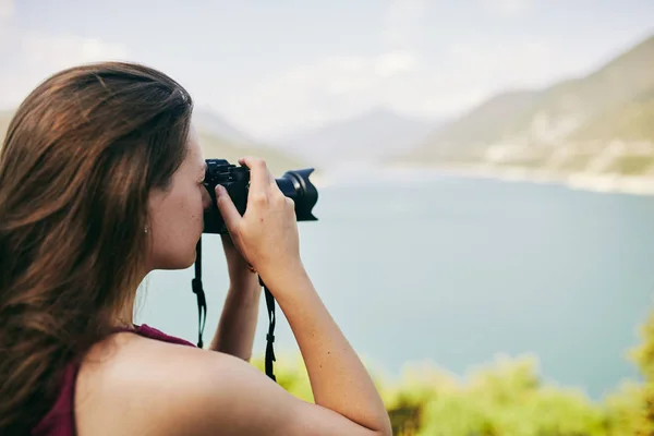 若い観光客の女の子は、山と湖の写真を撮る。グルジア。夏。8 月. — ストック写真