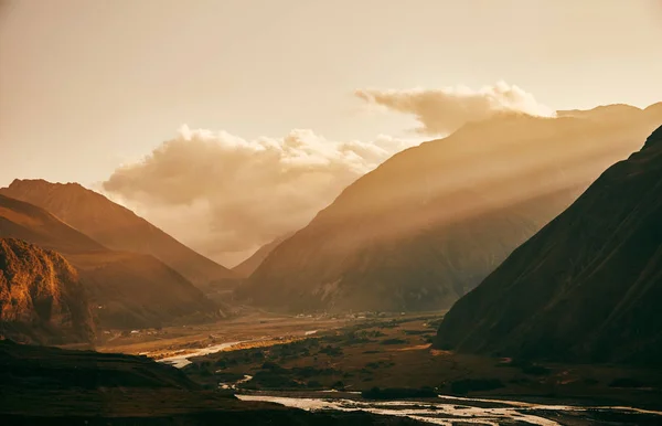 Puesta de sol en las montañas. Montañas caucásicas. Monte Kazbek. Rayo solar —  Fotos de Stock