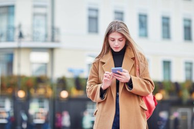 Genç Rus kız telefonda bir ileti yazmakta olduğunu. Bir kız Sms mesajı yazar. Sosyal ağlarda iletişim kurar