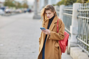 Genç Rus kız telefonda bir ileti yazmakta olduğunu. Bir kız Sms mesajı yazar. Sosyal ağlarda iletişim kurar