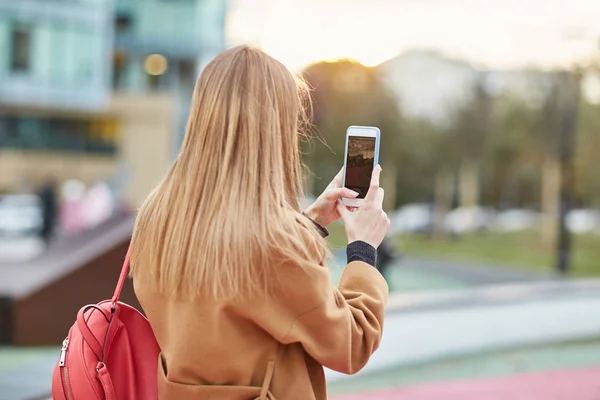 Uma jovem tira uma foto no centro da cidade. Menina tirando fotos em seu telefone. centro de Moscou . — Fotografia de Stock