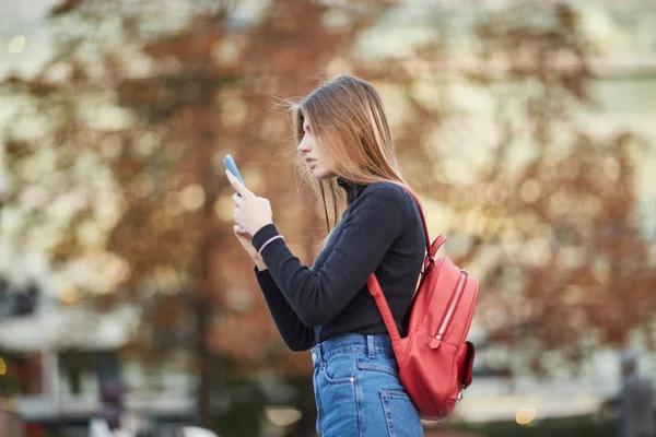 ロシア少女が携帯電話のメッセージを入力します。女の子は、Sms メッセージを書き込みます。ソーシャル ネットワークで通信します。 — ストック写真