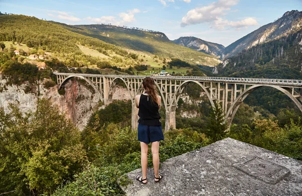 Una giovane ragazza fotografa il ponte Dzhurdzhevicha. Fotografie turistiche attrazione. Montenegro . — Foto Stock