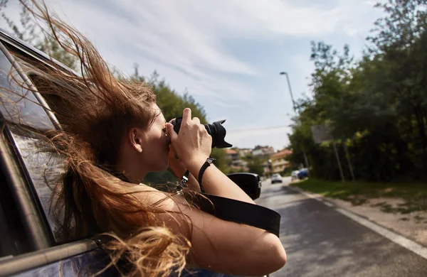 Junges weißes Mädchen beim Fotografieren aus dem Autofenster. Montenegro. — Stockfoto