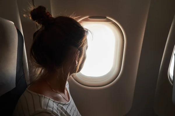 Mädchen schauen aus dem Fenster des Flugzeugs. — Stockfoto
