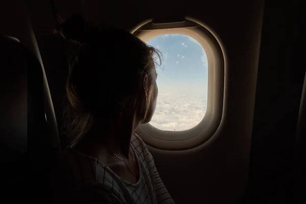 女孩看着窗外的飞机. — 图库照片